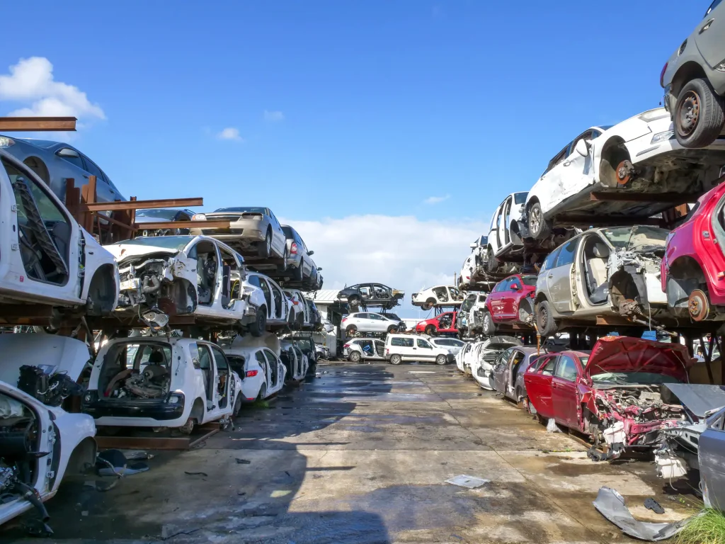 Rows of end-of-life cars stacked on racks in a vehicle recycling yard