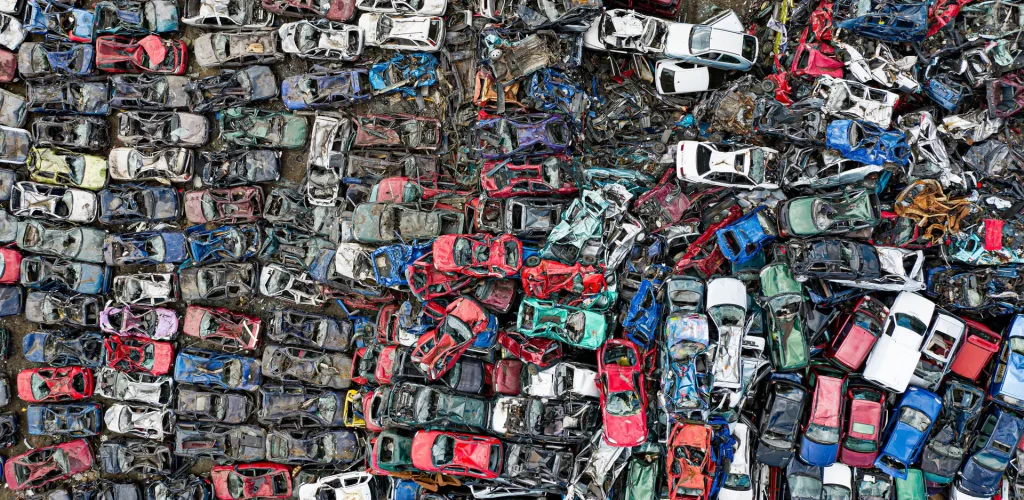 An aerial view of hundreds of scrapped cars in a recycling yard
