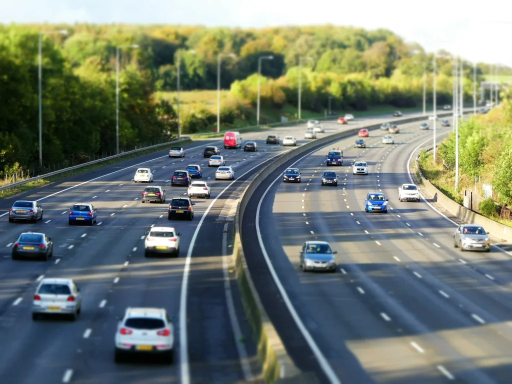 Traffic on a curving UK motorway lined with trees